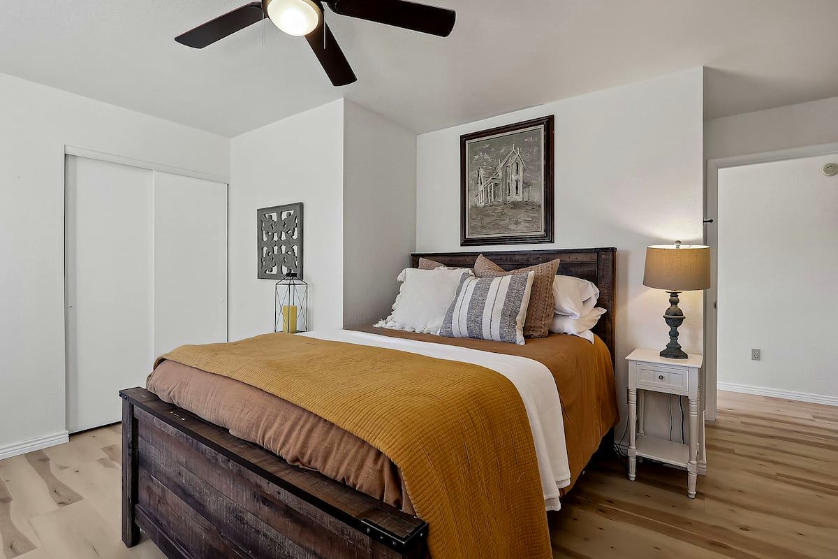 Bedroom with queen bed and warm mustard throw